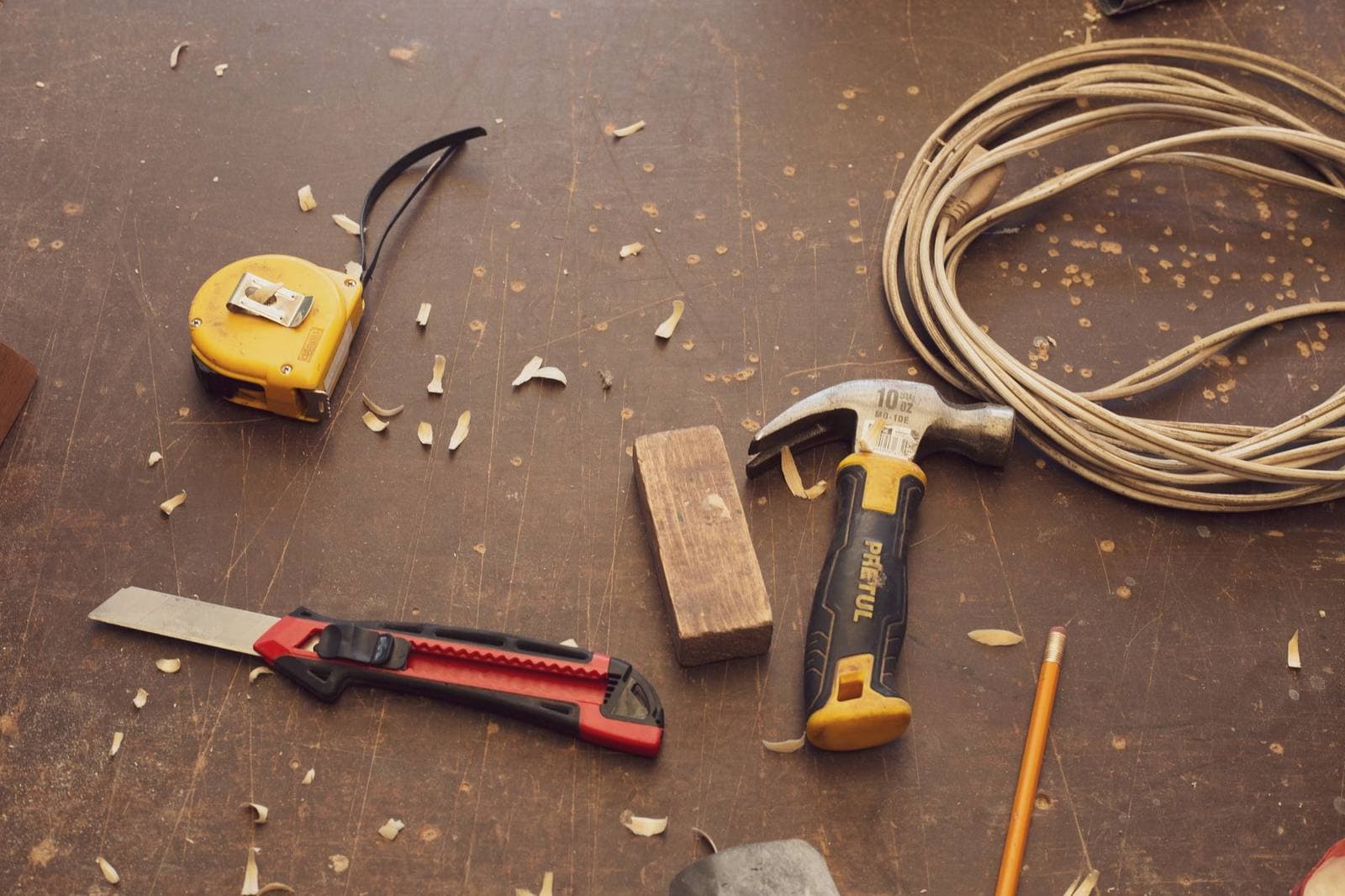 Small woodworking hand tools and a carpenter pencil laid out on a workbench